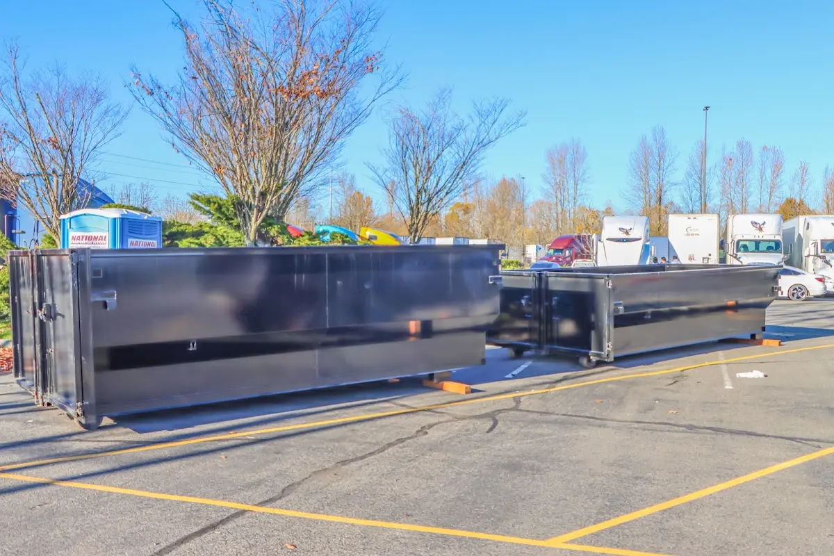 Professional dumpster rental service with roll-off container on residential driveway in New Boston